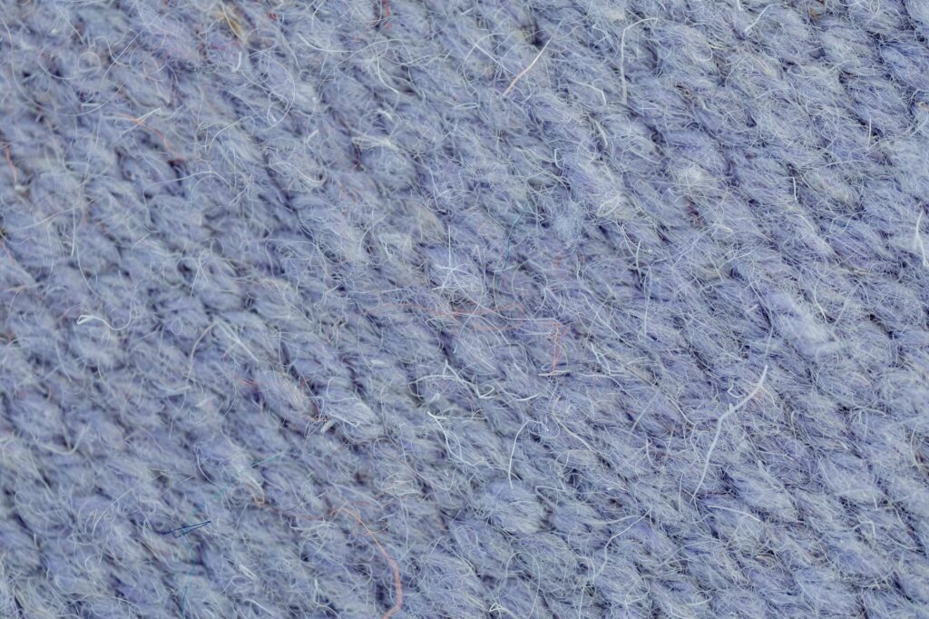 Gros plan sur la maille serrée d'un tricot de laine bleu clair