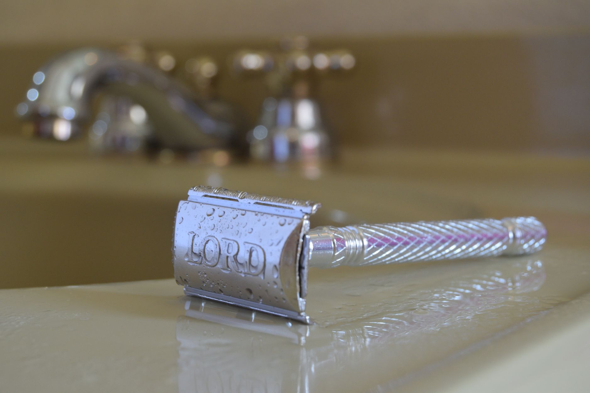 Rasoir de sûreté en métal posé sur le rebord d'un lavabo