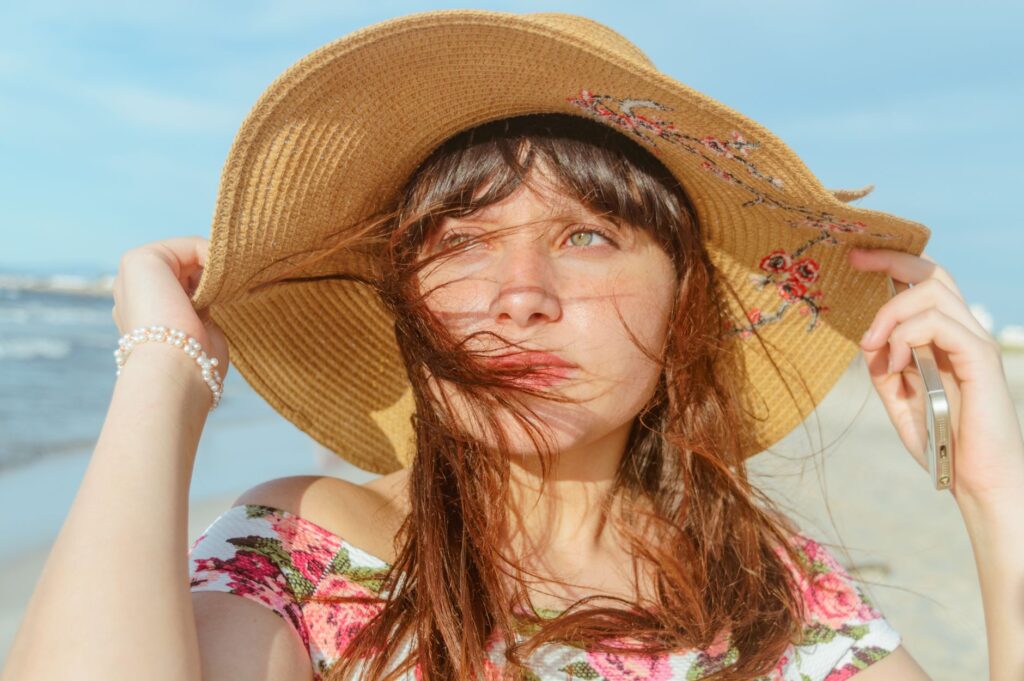 Jeune femme en chapeau de paille à large bord sur la plage