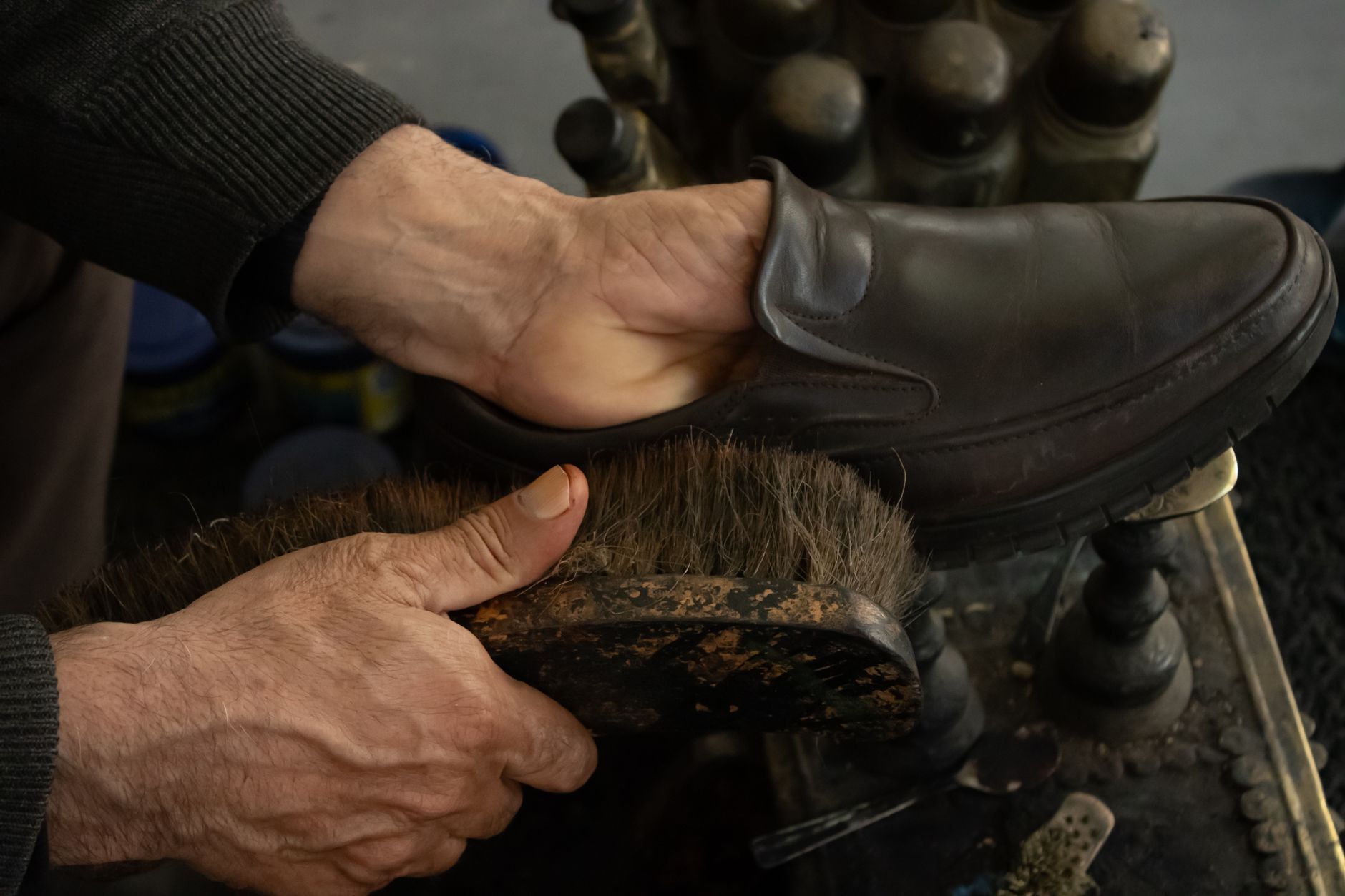 Chaussure en cuir noir lustrée à la brosse chez un cireur de rue