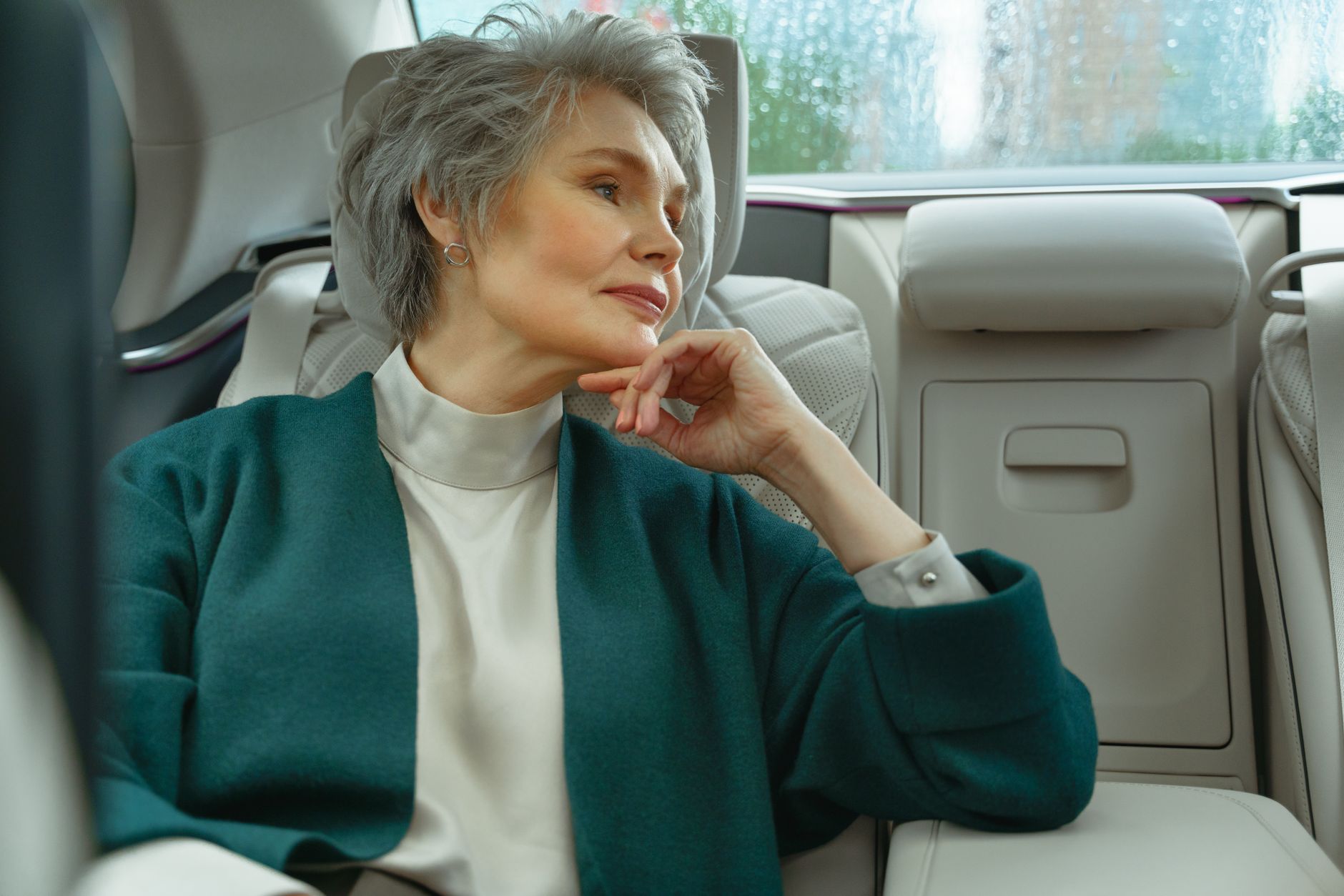 Femme sénior aux cheveux courts gris assise à l'arrière d'une voiture