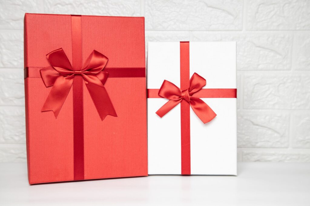 Deux coffrets cadeaux rouge et blanc noués de rubans satinés